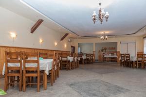 a dining room with tables and chairs and a chandelier at Pensiunea Radu in Cisnădie