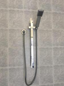 a shower head on a tiled floor with a toothbrush at Deco City Motor Lodge in Napier