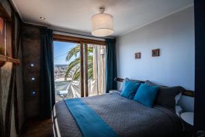 um quarto com uma cama com almofadas azuis e uma janela em Patio Ferreiro B&B em Cartagena