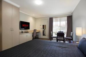 a hotel room with a bed and a television at Elm Tree Motel in Warrnambool