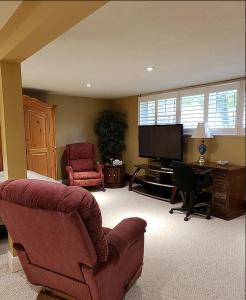 a living room with a couch and a television at Forest Hill Bed and Breakfast in Kitchener