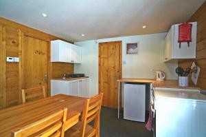 a kitchen with a wooden table and a counter top at La Coterie Lodges in Blaudeix