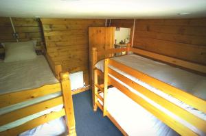BlaudeixにあるLa Coterie Lodgesの木製の壁の客室で、二段ベッド2組が備わります。