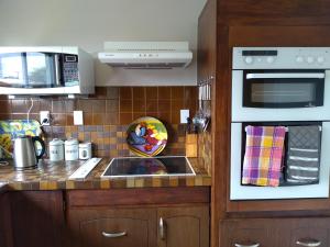 a kitchen with a sink and a microwave at Ironsands B&B in Patea