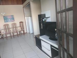 una sala de estar con TV y una habitación con sillas en cantinho do yuji, en Cabo Frío