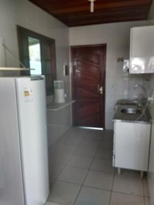 Una cocina con refrigerador y fregadero. en cantinho do yuji, en Cabo Frío