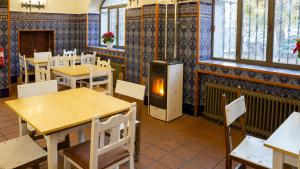a restaurant with tables and chairs and a heater at Hostel La Pedriza in Manzanares el Real