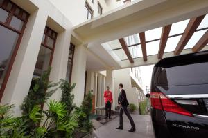 two men walking outside of a building at Wimarion Hotel Semarang in Semarang