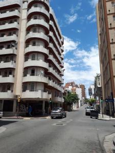 un edificio alto en una calle de la ciudad con un coche en mi depto en cba en Córdoba