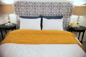 a bed with a yellow blanket on top of it at Fortaleza Suites Old San Juan in San Juan