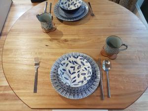 a wooden table with plates and utensils on it at Chalet Karaka in Takaka