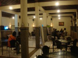 un grupo de personas sentadas en mesas en un restaurante en Sunset View Carita by Augusta hotel, en Sukanegara