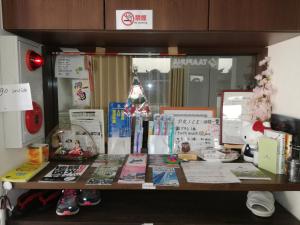 a desk with books and other items on it at Fukuoka Guest House Jikka in Fukuoka