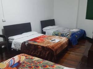 a room with three beds and a table in it at Hotel San Agustín in San Agustín