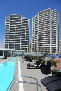 a hotel swimming pool with two tall buildings at Club Océano La Serena 2do piso in Coquimbo