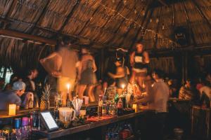 un bar con un grupo de personas en una habitación en Los Hermanos Beach Hostal, en Guachaca