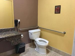 a bathroom with a white toilet and a phone at Diamond Inn in Inglewood