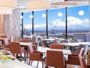 a restaurant with tables and chairs and a view of a mountain at HOTEL MYSTAYS Fuji Onsen Resort in Fujiyoshida