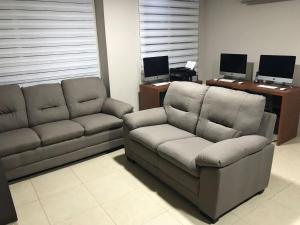 sala de estar con sofá y silla en 1310 Luxury Room near of the Airport - Edificio Kennedy Town Center #403, en Guayaquil