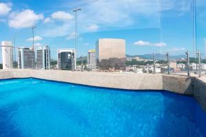 a swimming pool on top of a building with a city skyline at 1310 Luxury Room near of the Airport - Edificio Kennedy Town Center #403 in Guayaquil