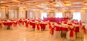 un salón de banquetes con mesas blancas con arcos rojos en Benguet Prime Hotel, en Baguio