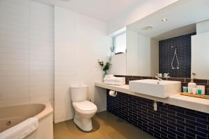 een badkamer met een toilet, een wastafel en een bad bij Lorne Bay View Motel in Lorne