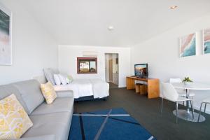 a living room with a couch and a bed at Lorne Bay View Motel in Lorne