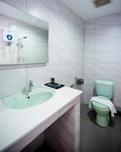 ein weißes Bad mit einem Waschbecken und einem WC in der Unterkunft H Boutique Hotel Xplorer Cheras in Kuala Lumpur