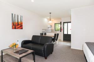 uma sala de estar com um sofá e uma mesa em Kauri Park Motel em Kerikeri