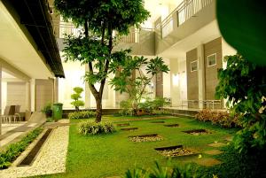 un patio con césped y árboles en un edificio en The Sriwijaya Hotel - Halal Hotel, en Padang