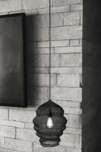 a light hanging from a wall with a brick wall at The Slow in Canggu