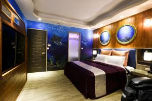 sypialnia z dużym łóżkiem i malowidłem rybnym w obiekcie Meng Siang Motel w mieście Pingzhen