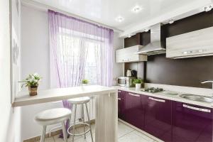 ケメロヴォにあるApartments on Lenina street 51の紫色のキャビネットと窓付きのキッチン