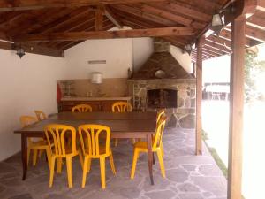 Villa Nanevi في تيتيفين: غرفة طعام مع طاولة خشبية وكراسي صفراء