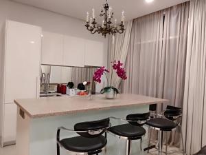 a kitchen with a island with four bar stools at Soho Suites KLCC Elite 2 in Kuala Lumpur