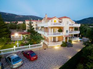 a large house with two cars parked in a driveway at Madalena's Apartment in Razáta