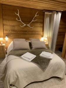 a bedroom with a large bed with two towels on it at Chez Fred et Carine (Petit-déjeuner bio inclus) in Auron