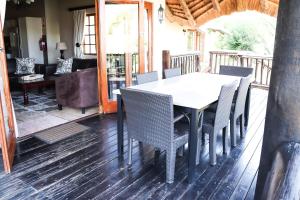 a dining room table and chairs on a deck at The Old Hatchery in Underberg