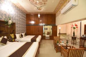 a hotel room with two beds and a dining room at Virasat Mahal Heritage Hotel in Jaipur