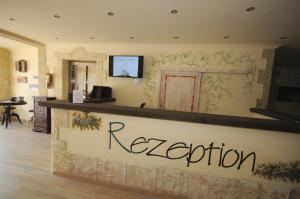 a hotel reception desk with a sign on the wall at Seehotel Europa in Schwanau