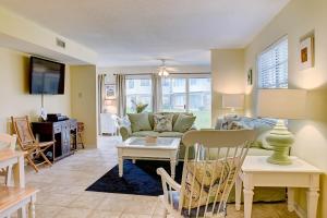 a living room with a couch and a table at Surf Club in Dauphin Island