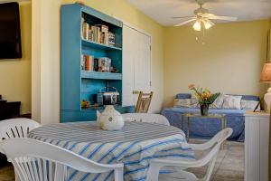 a dining room with a table and a blue book shelf at Surf Club in Dauphin Island