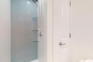 uma casa de banho com um chuveiro com azulejos azuis em Provincetown Paradise em Provincetown