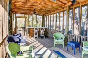 a screened in porch with chairs and a bar at Surf Club in Dauphin Island