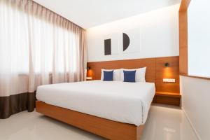 a bedroom with a large white bed with blue pillows at Barayan place in Na Jomtien