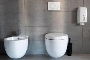 een badkamer met een wit toilet en een wastafel bij TrentoApartment in Trento