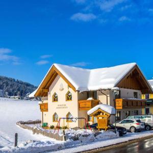 ein Gebäude mit einem schneebedeckten Dach im Schnee in der Unterkunft Flachauer Bergkristall in Flachau