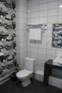 Łazienka z białą toaletą i umywalką w obiekcie Hotel Inju Hills w mieście Astana