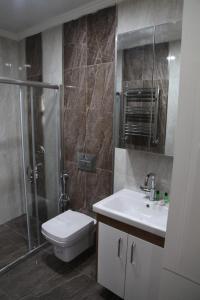 een badkamer met een douche, een toilet en een wastafel bij family apart hotel in Istanbul