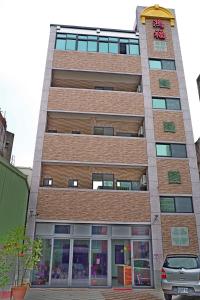 a tall brick building with a car parked in front of it at Hongfu Elegant Business Hotel in Zhongli